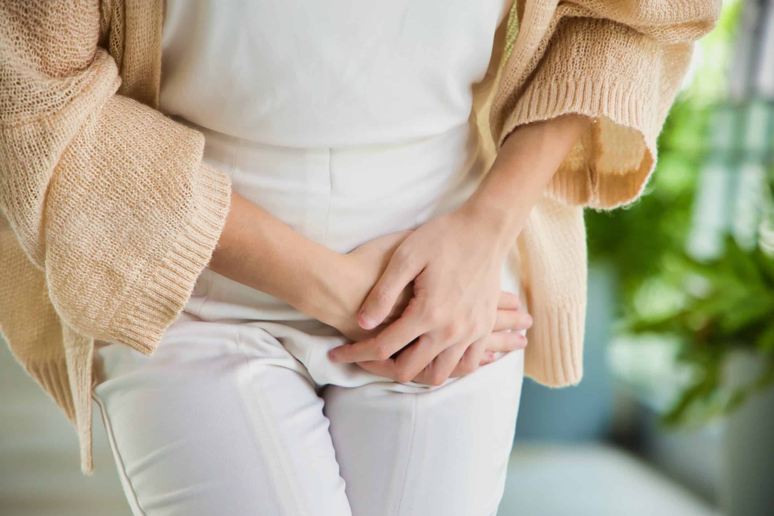 Woman looking like she is trying prevent peeing due to urinary incontinence